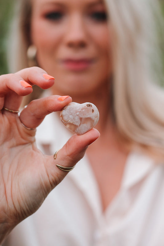 Flower Agaat hartje dat wordt vastgehouden door Joyce Lemmens die je wazig in de achtergrond ziet.
