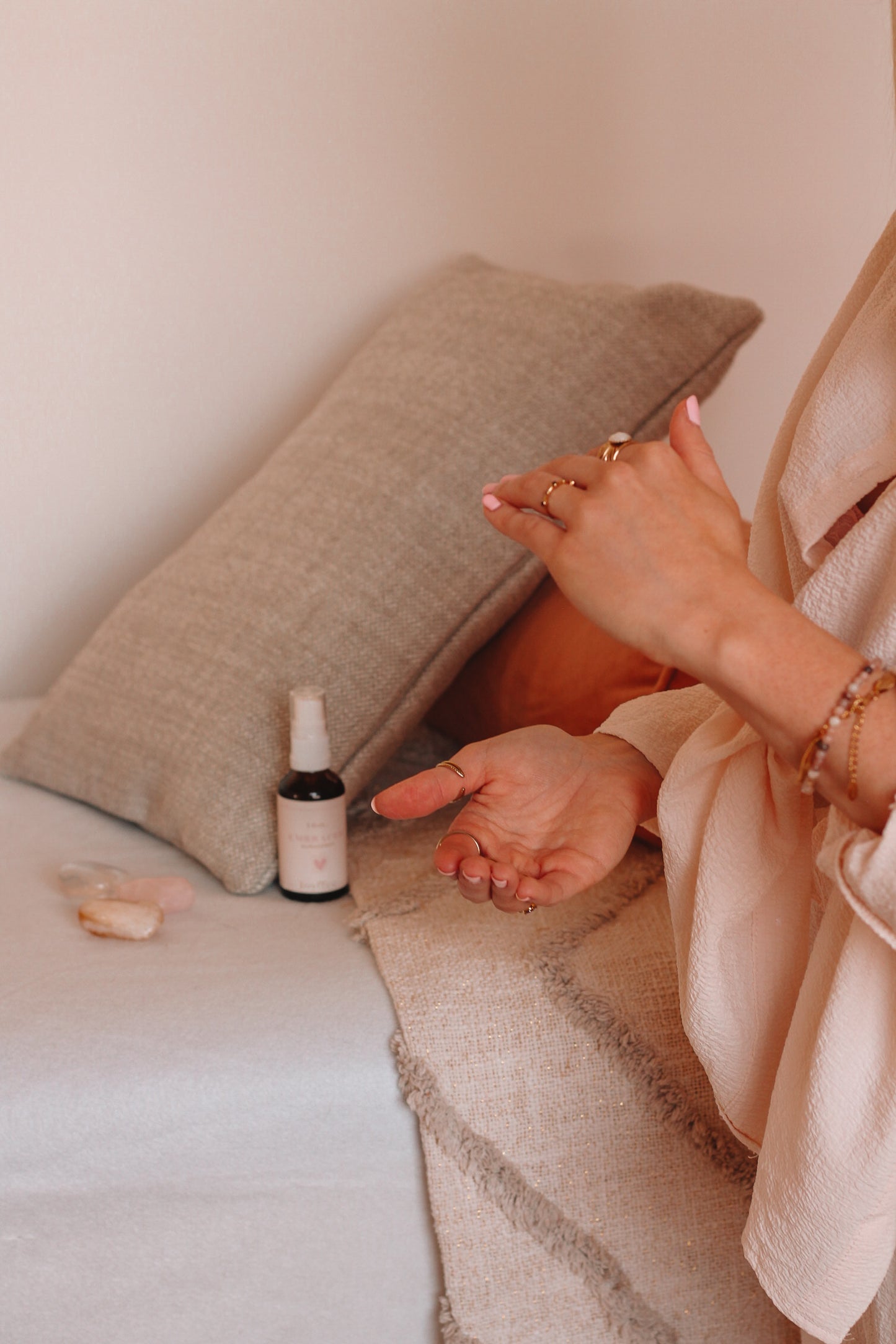 Shot van de I feel embraced aura spray in de meditatieruimte naast edelstenen