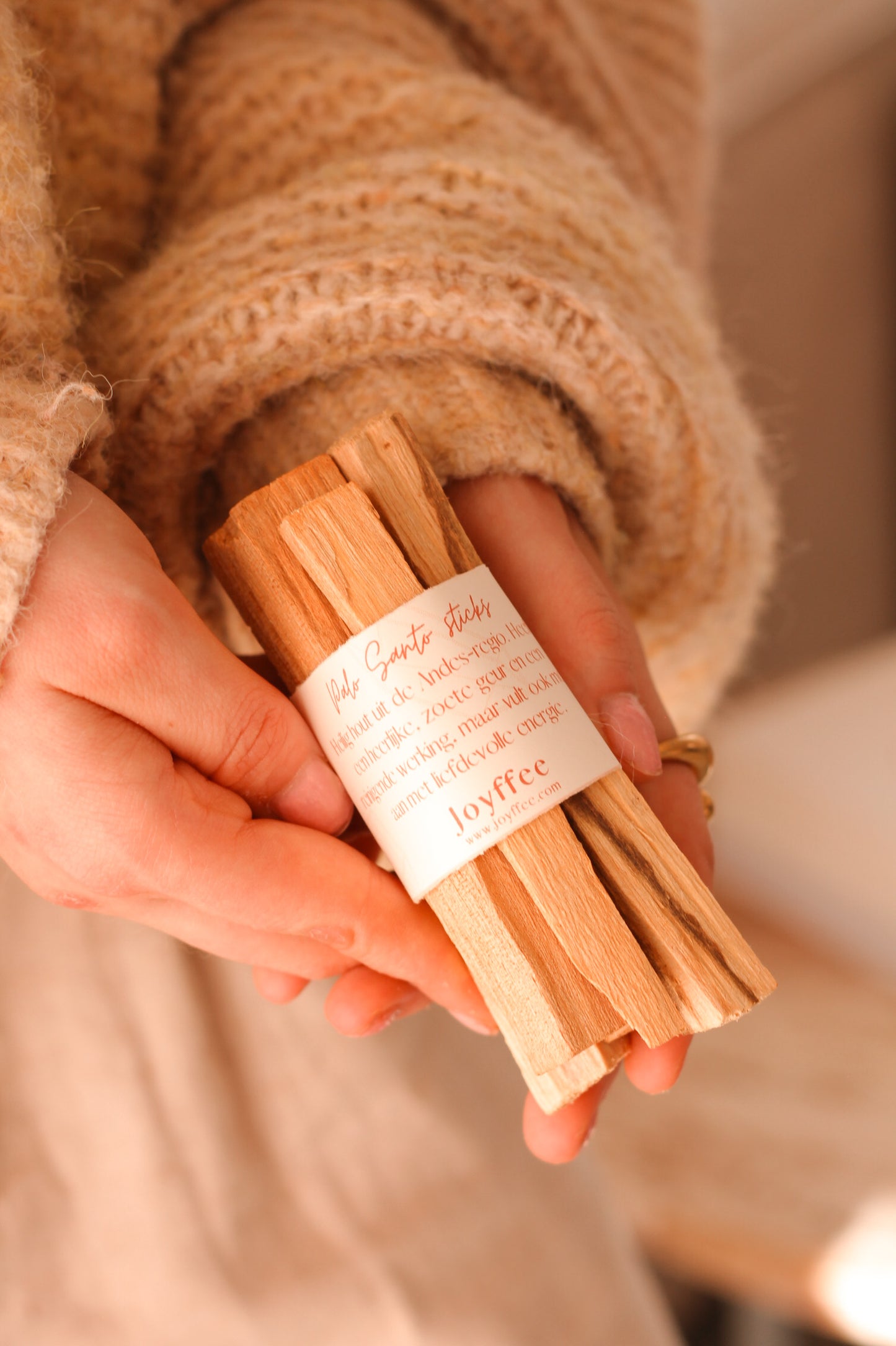 Een persoon houdt een set van 5 Palo Santo sticks vast.