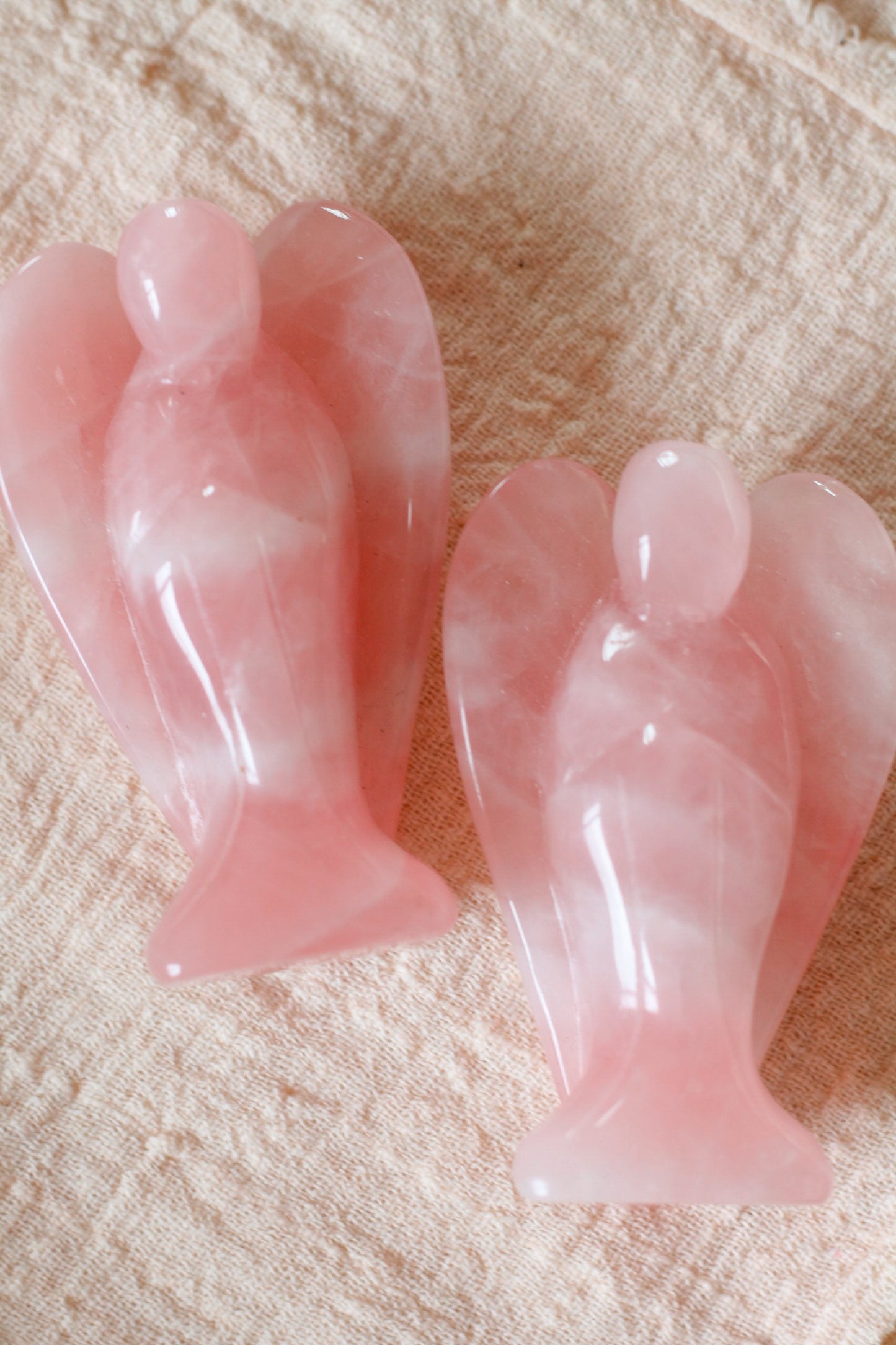 Productfoto van de Rozenkwarts beschermengeltjes, liggend op een beige ondergrond.