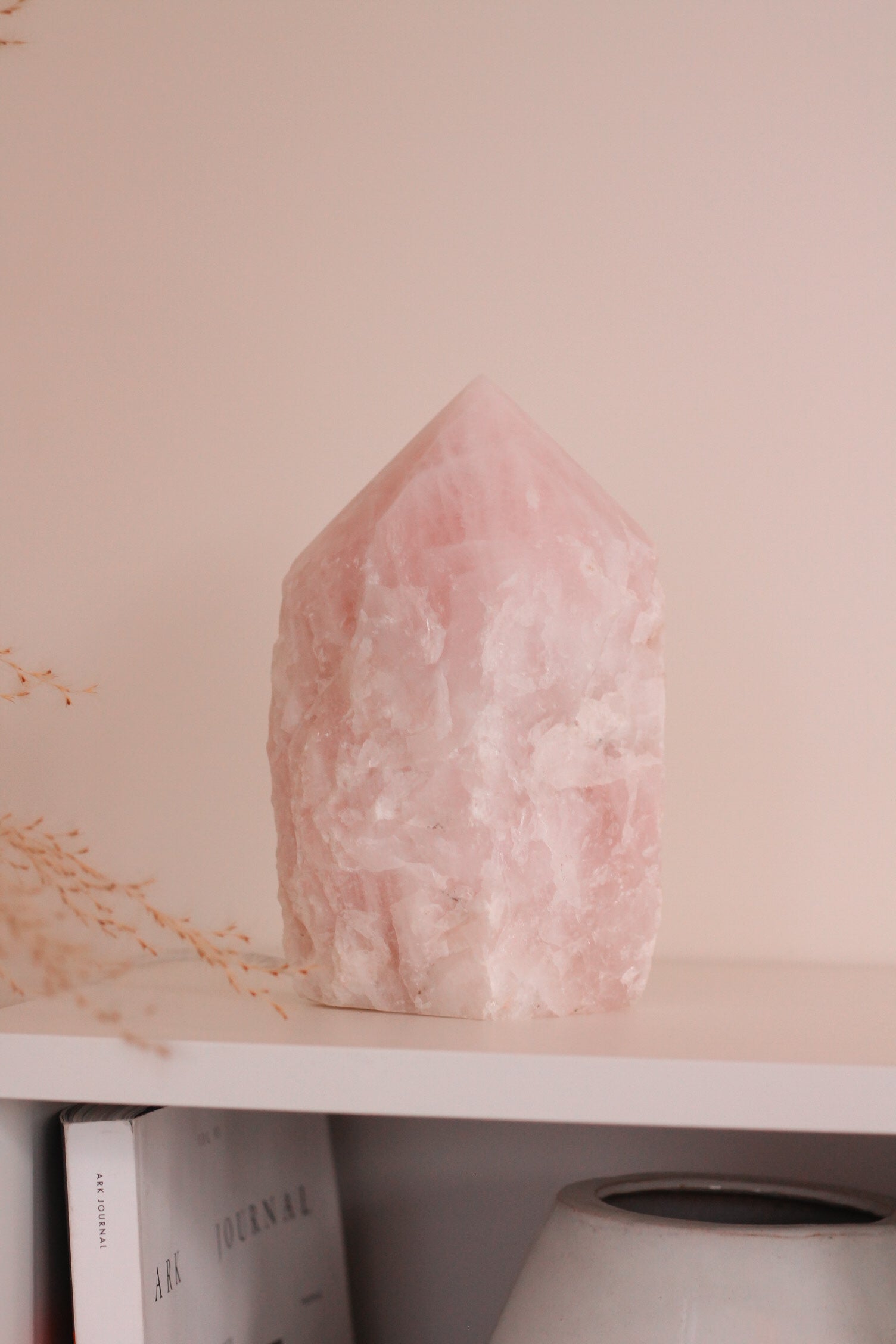Detail foto van de Rozenkwarts punt lamp, die op een witte kast staat. De lamp brand niet.