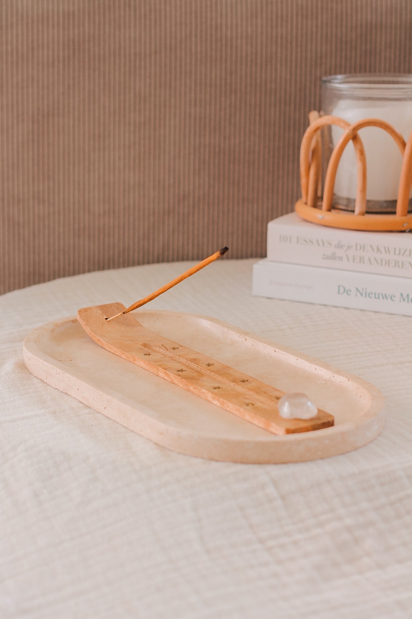 Wierookstokje brandend in wierookhouder met heldere bergkristal edelsteen.