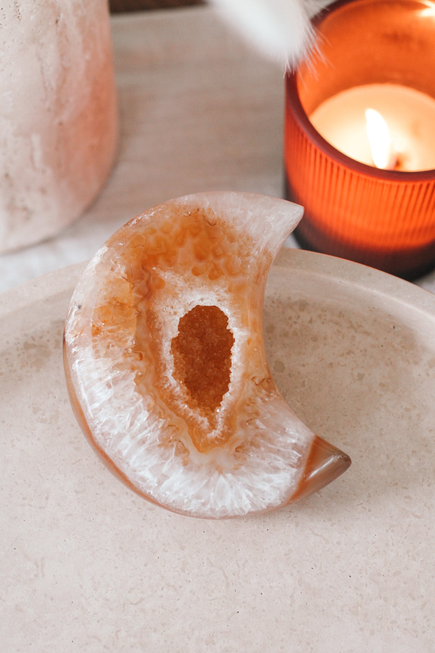 Close-up van de Druzy Agate moon Rustic Ivory op een beige plateau.