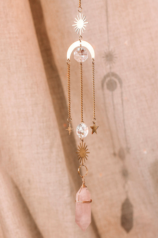 Suncatcher met feng shui kristallen en een kristal punt, bestaande uit een metalen zon en maan, met daaraan hangend verschillende kristallen en sterren